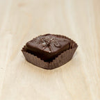 Chocolate candy in a wrapper on a light wooden surface
