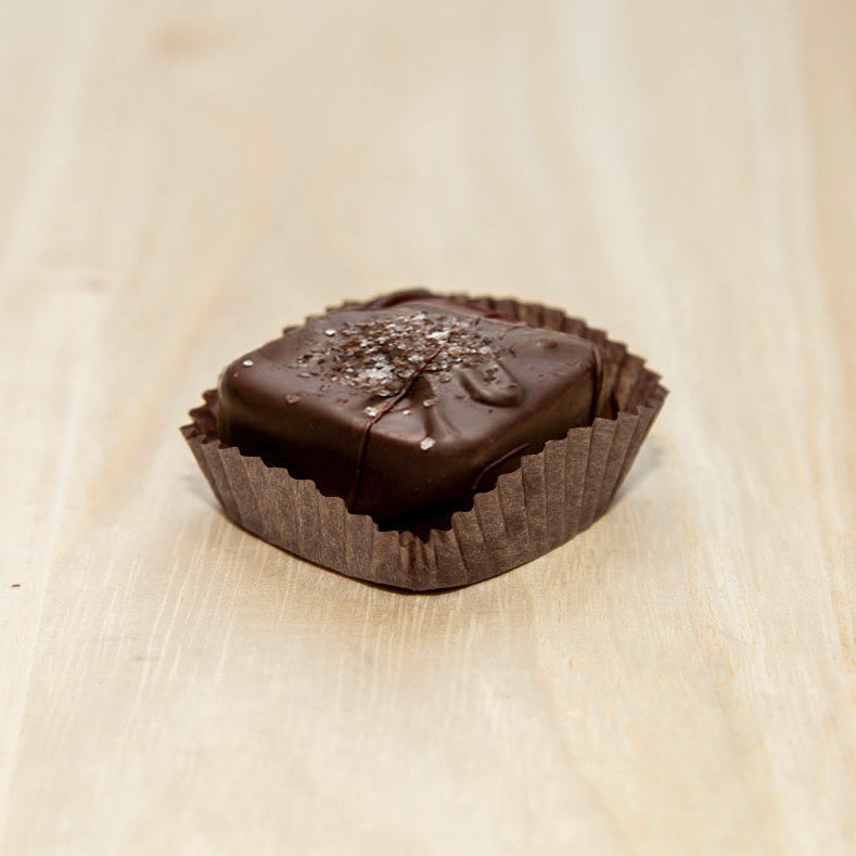 Chocolate candy in a wrapper on a light wooden surface